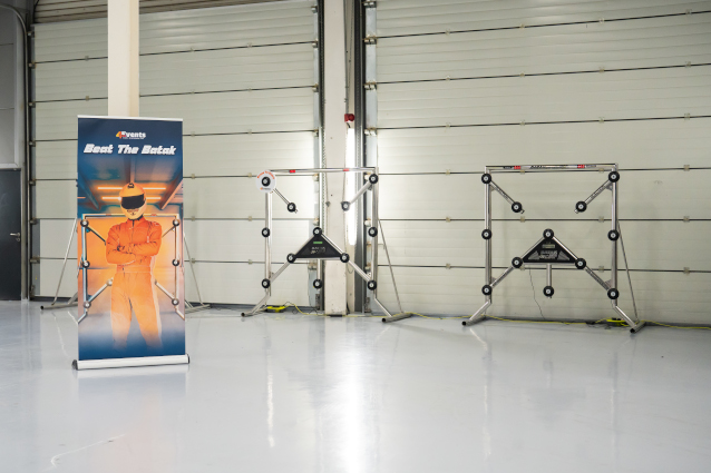 Event signage featuring a race car driver on display in a large room.