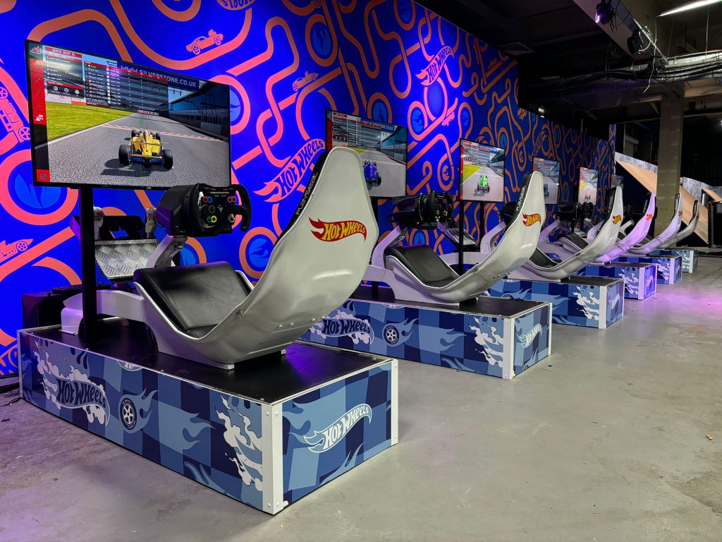 A row of Hot Wheels branded racing simulators.