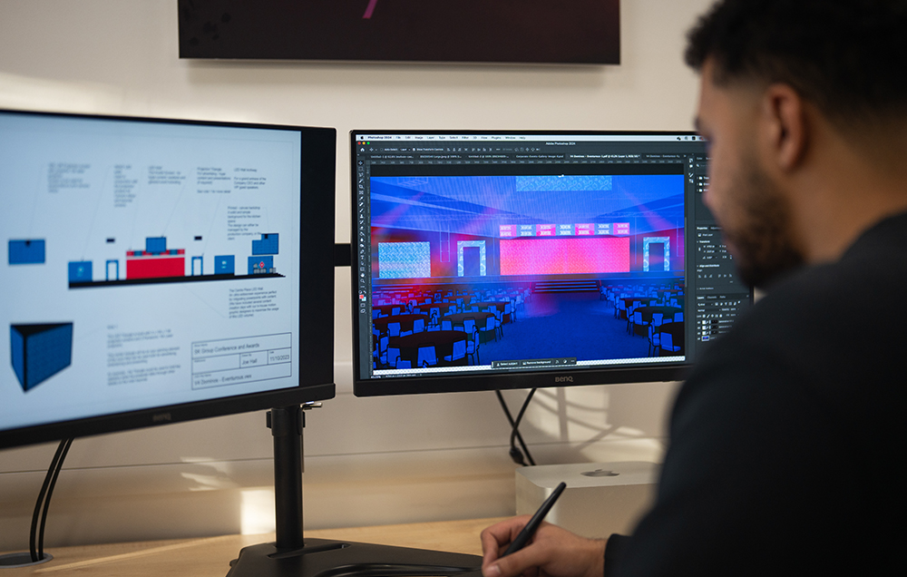 A man looking at two computer screens.